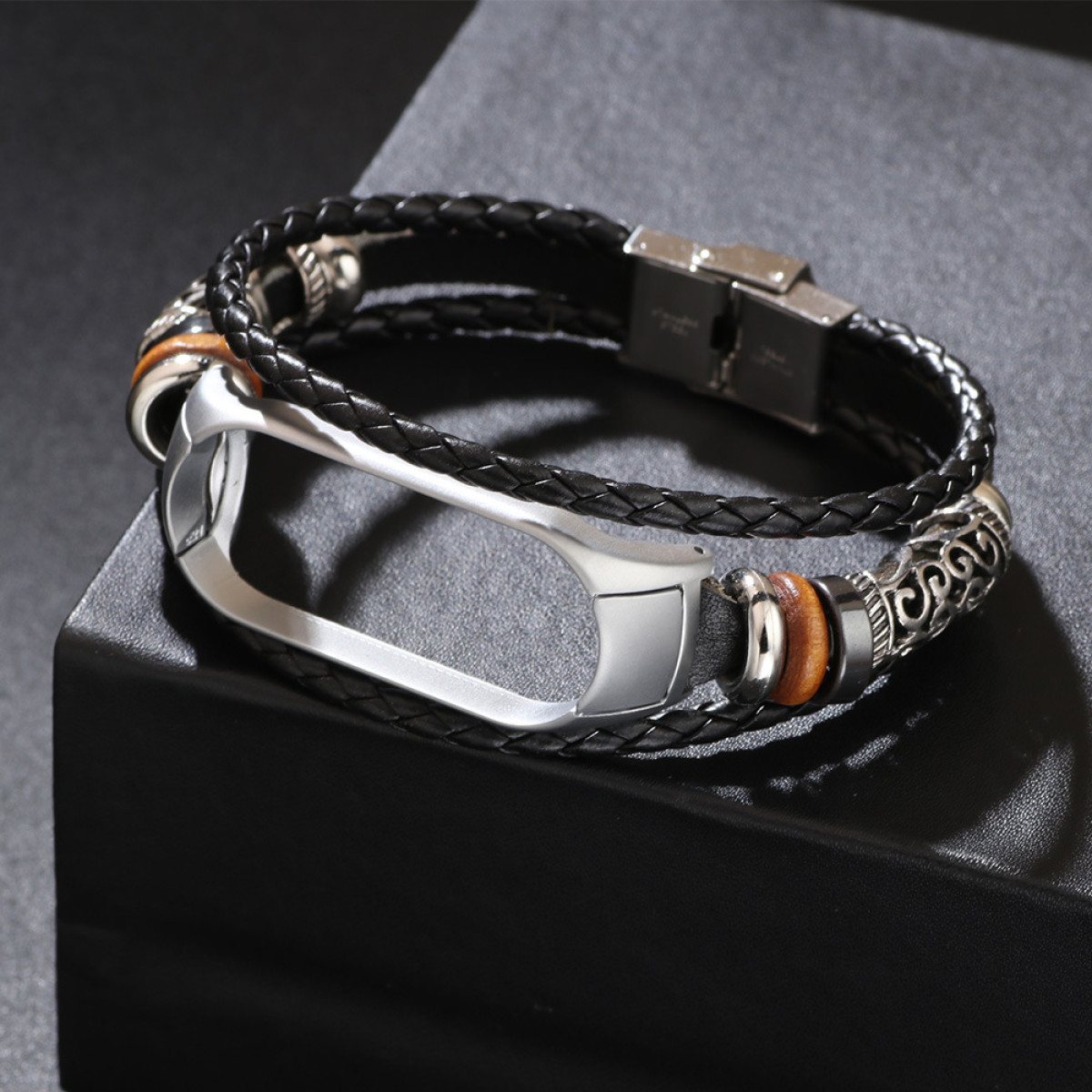 Bracciale in pelle nera e marrone con supporto argentato. Superficie nera.