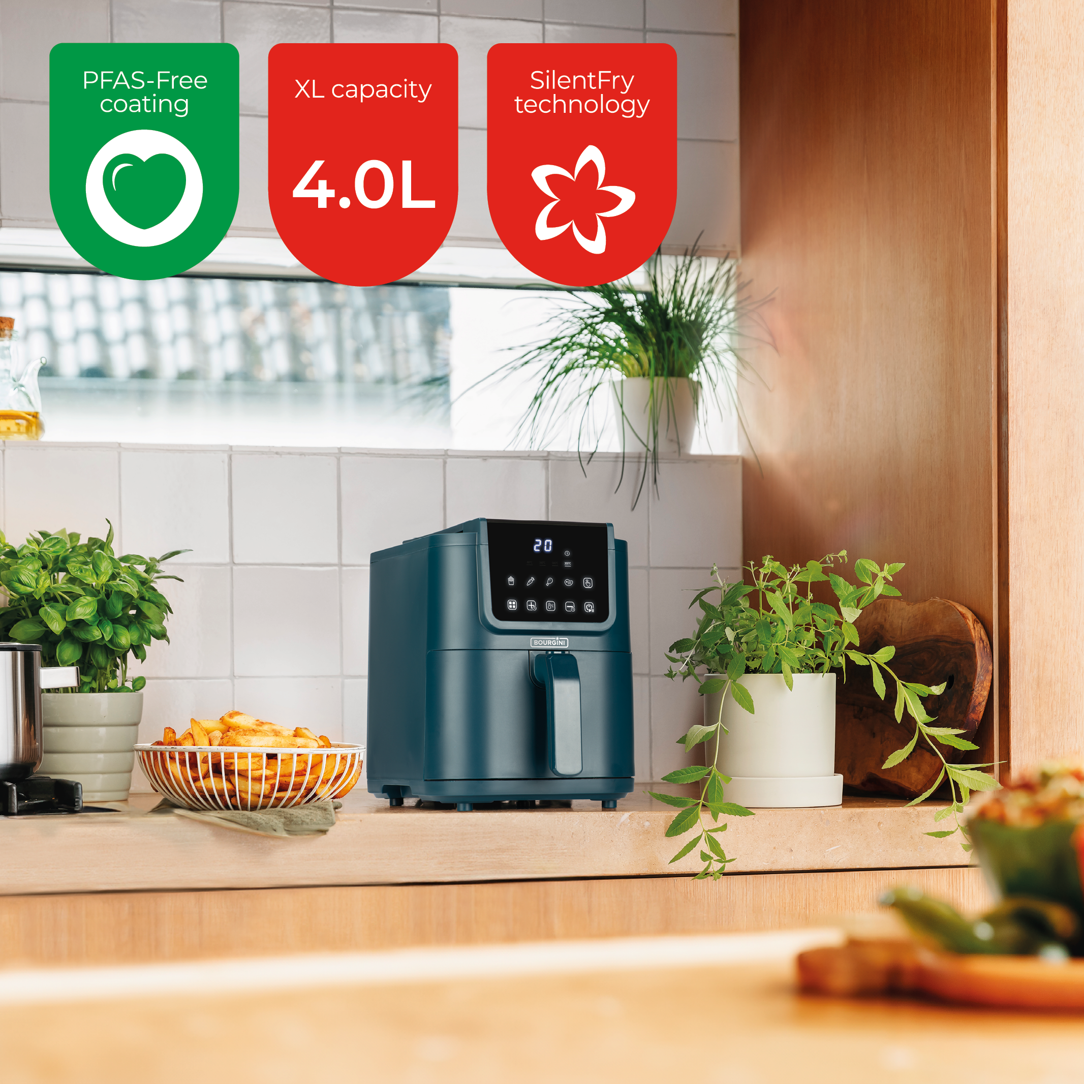 Turquoise airfryer met tekst en planten op een houten aanrecht.