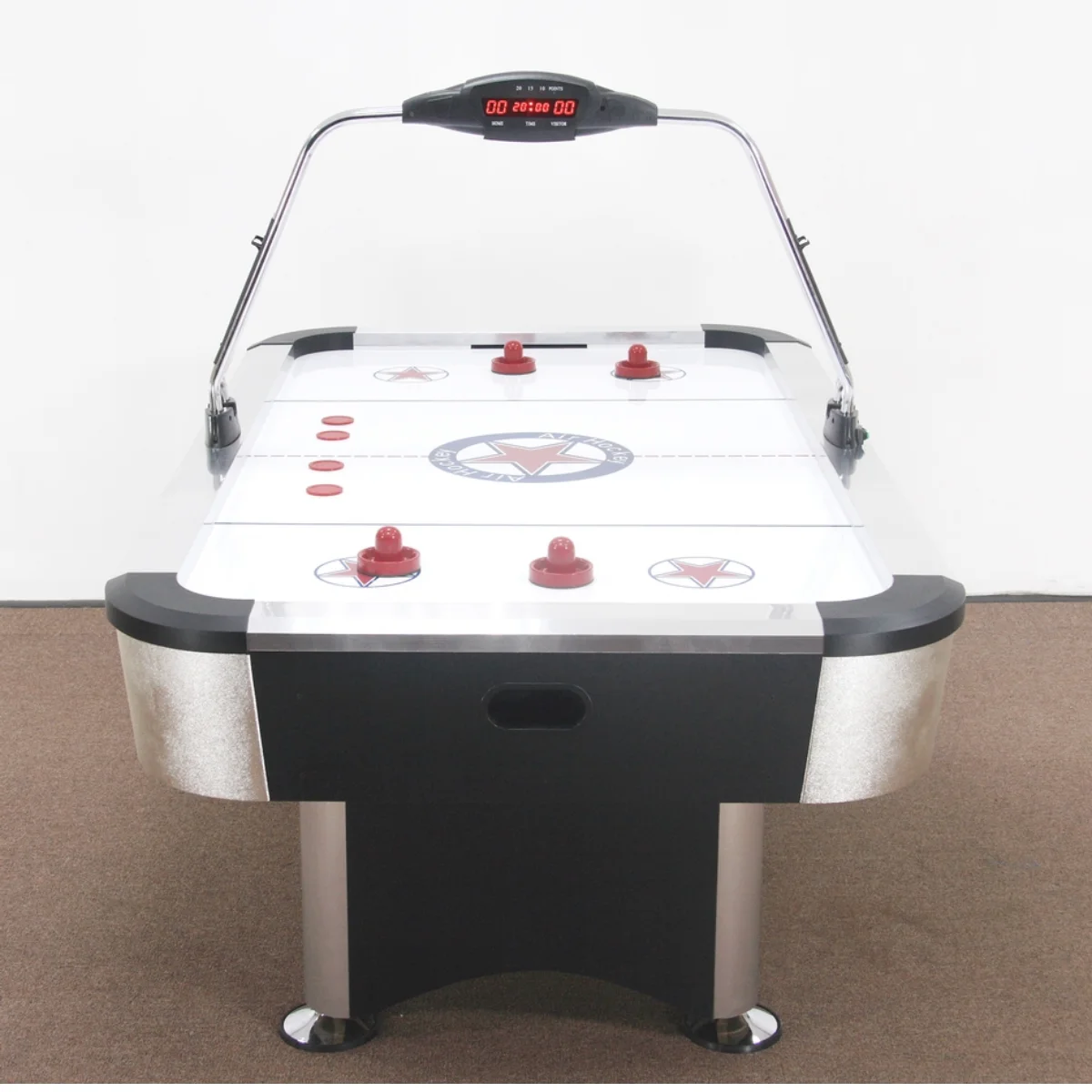 Un tavolo da air hockey con dischi e attaccanti rossi. Un display digitale è sopra la rete.
