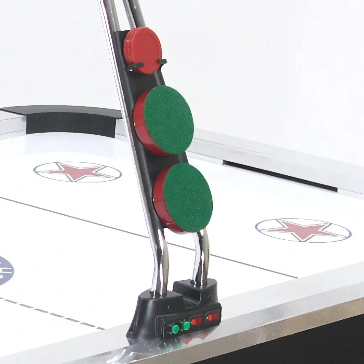 Dettaglio gioco air hockey: dischi, cuscinetti rossi/verdi, su superficie bianca. Supporti metallici, base nera, sfondo bianco.