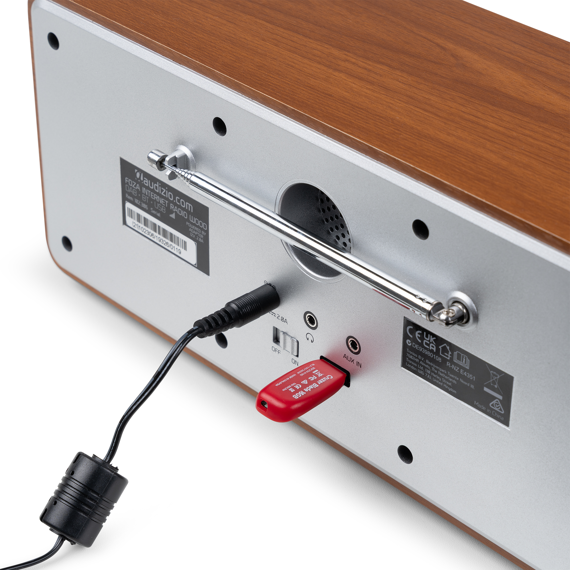Parte trasera de radio de madera con cable, memoria USB roja y antena metálica.