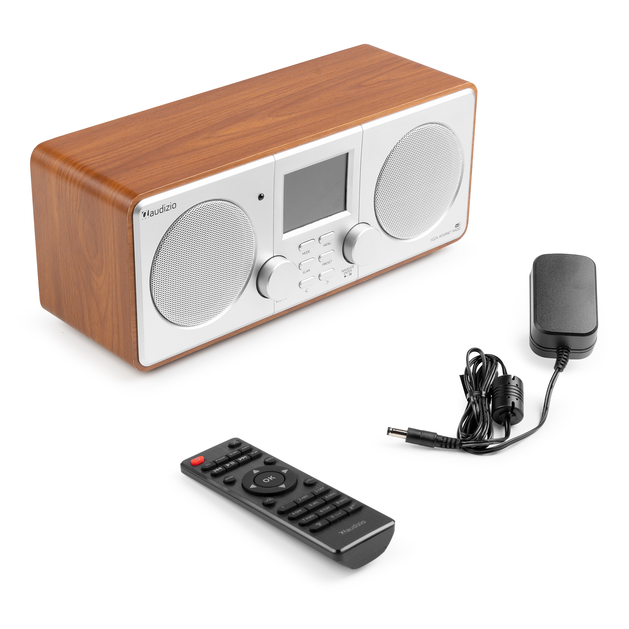 Una radio de aspecto de madera, un mando a distancia y un adaptador de corriente sobre una superficie blanca.