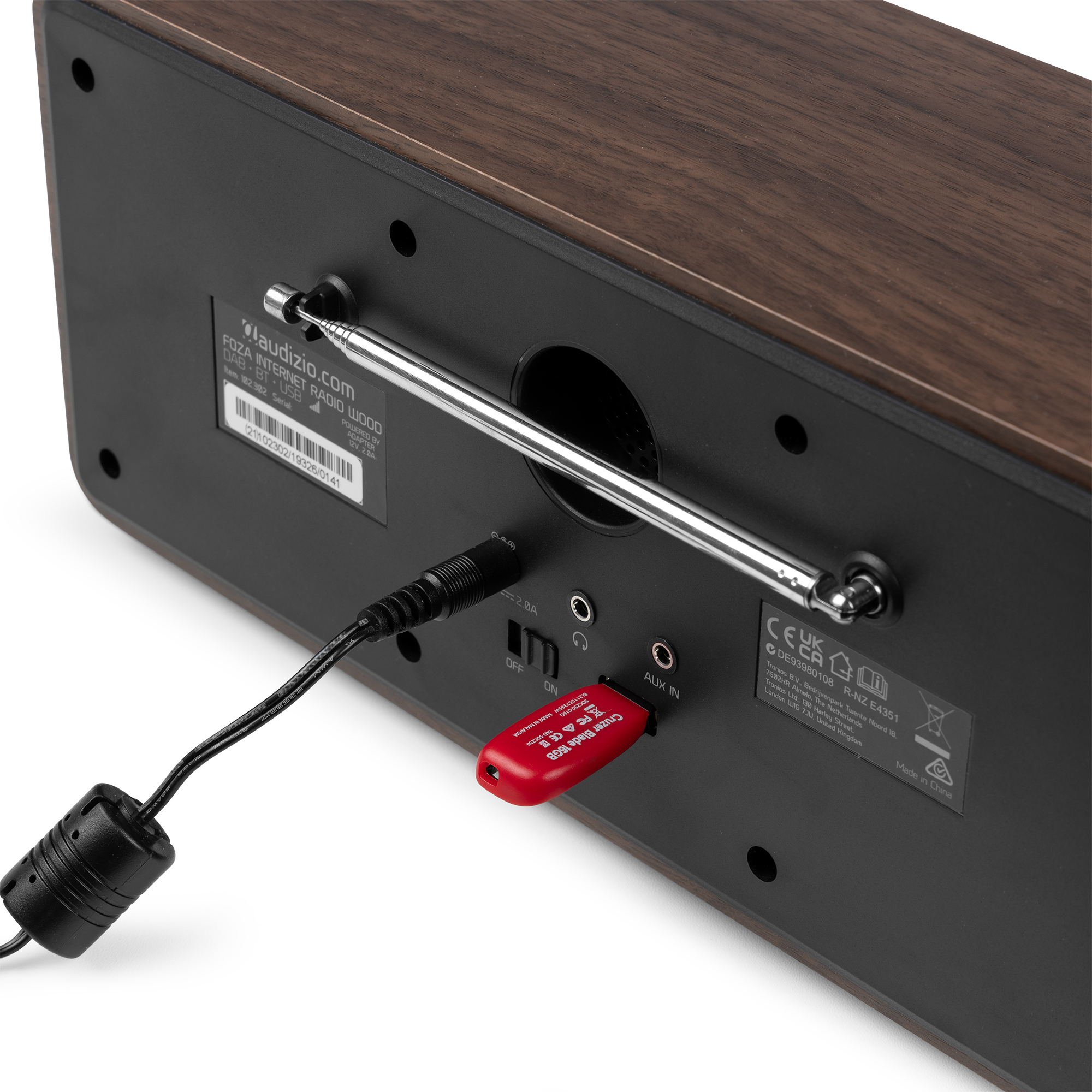 Parte trasera de una radio por internet de madera con una unidad USB roja y antena.