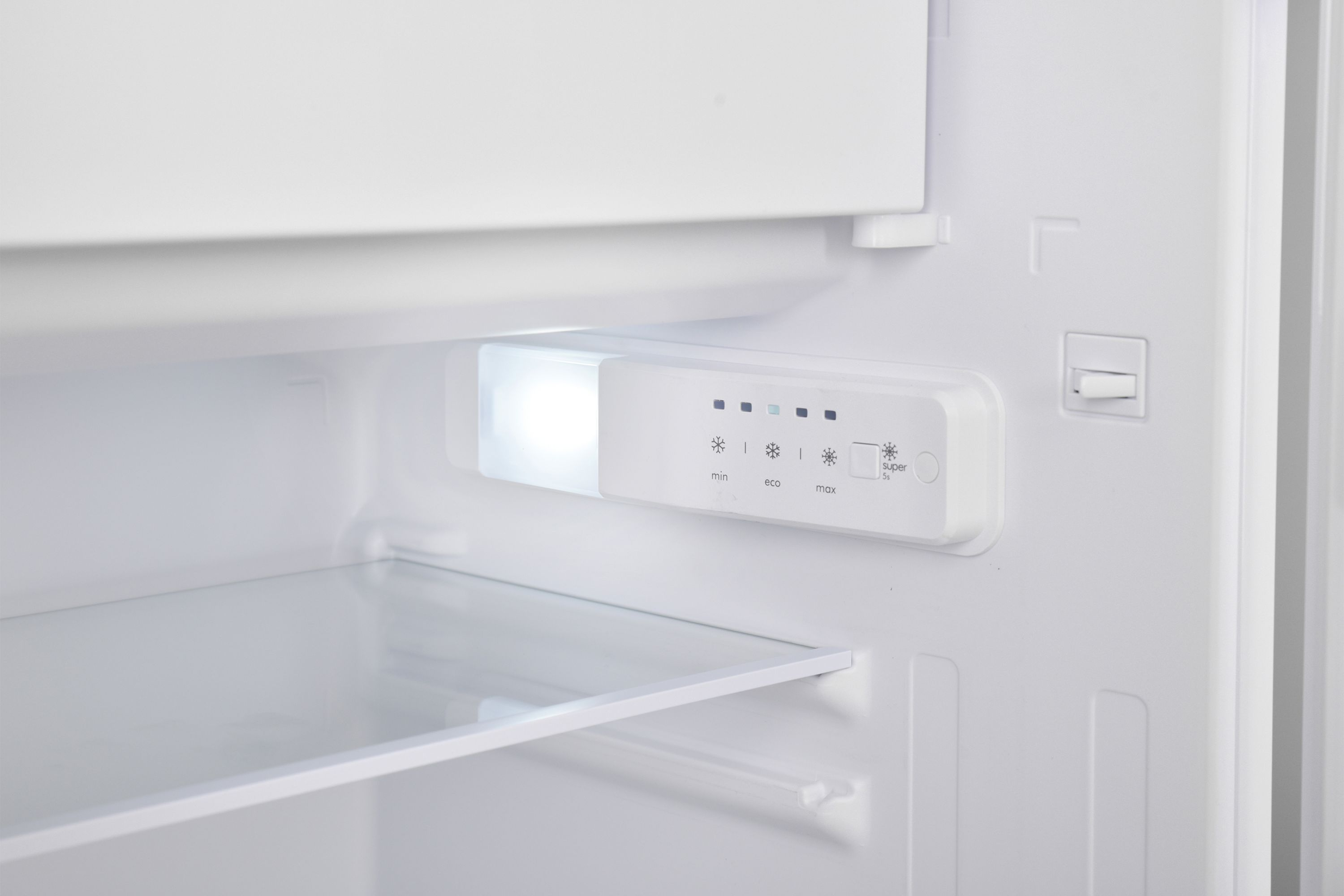 Ein offener Kühlschrank mit Licht. Der Innenraum hat Regale und die Temperaturregler sind sichtbar.