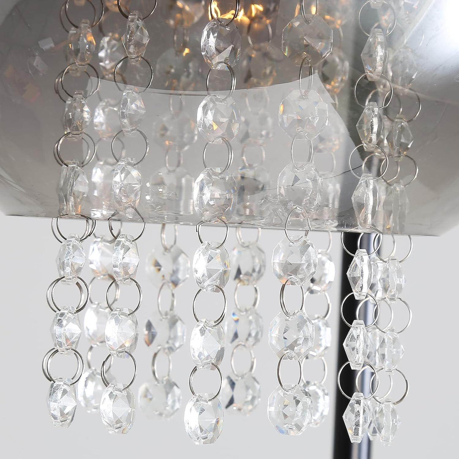 Zbliżenie żyrandola z kryształowymi kroplami. Srebrne łańcuchy i jasne światło.