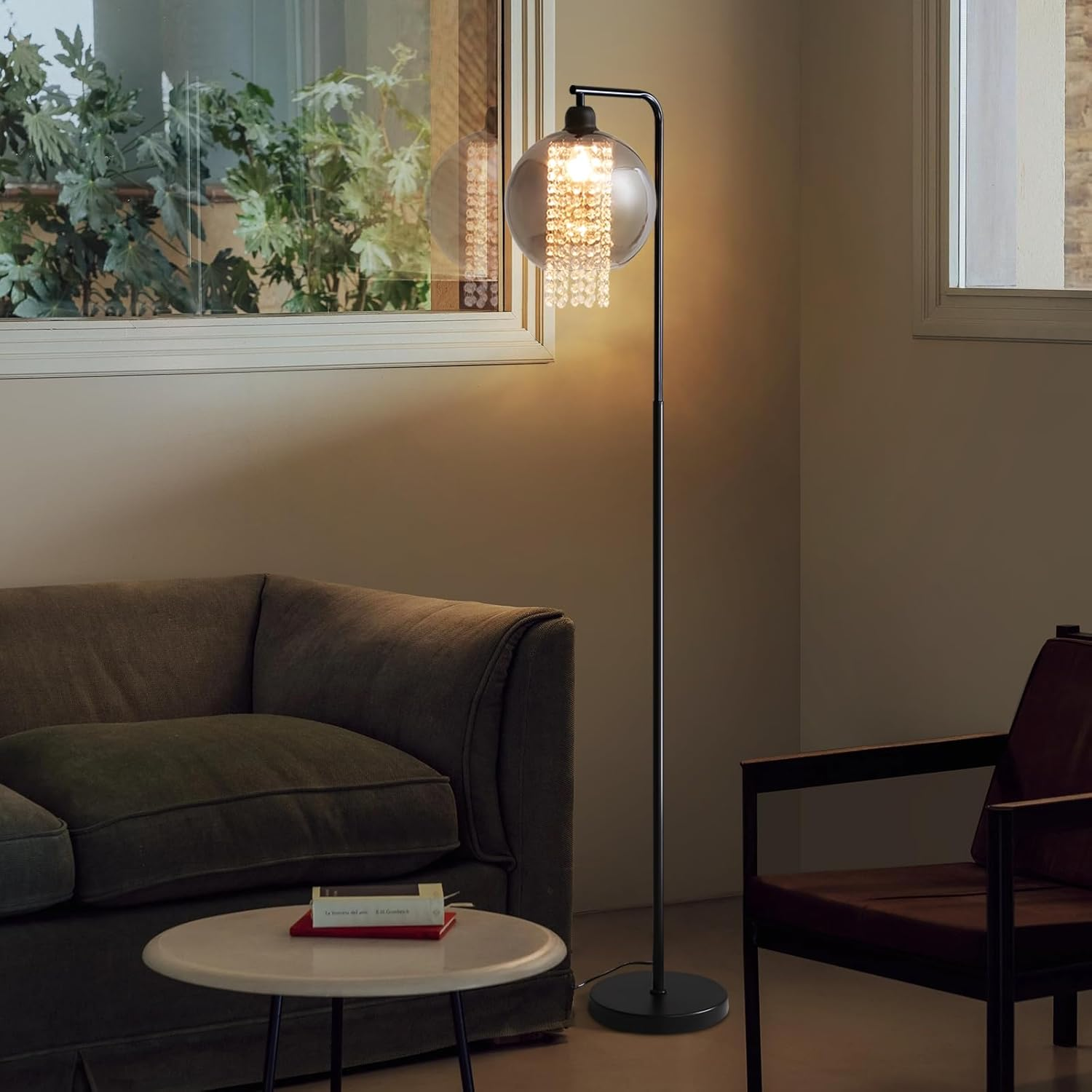 Czarna lampa podłogowa ze szklanym kloszem i kryształowymi akcentami w salonie.
