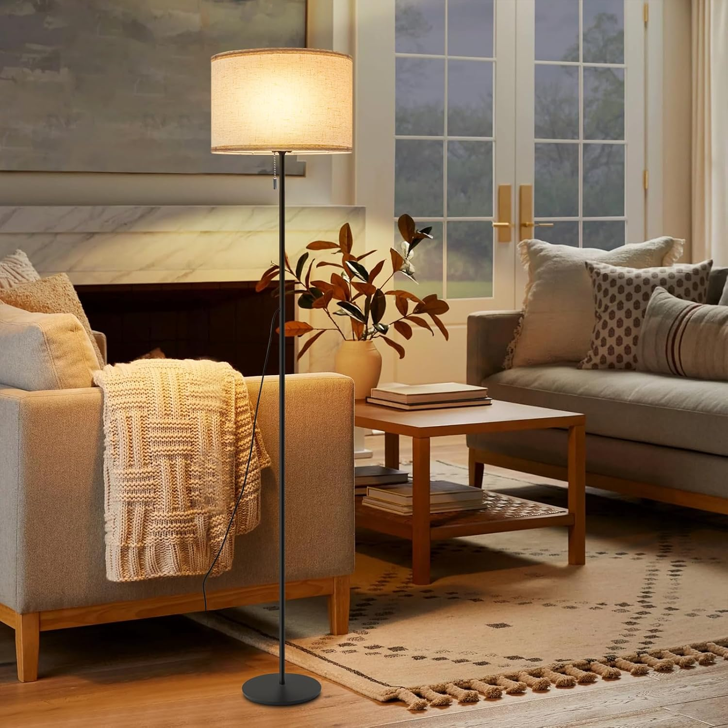 Salon z lampą podłogową, sofą, stolikiem kawowym, dywanem i oknem.