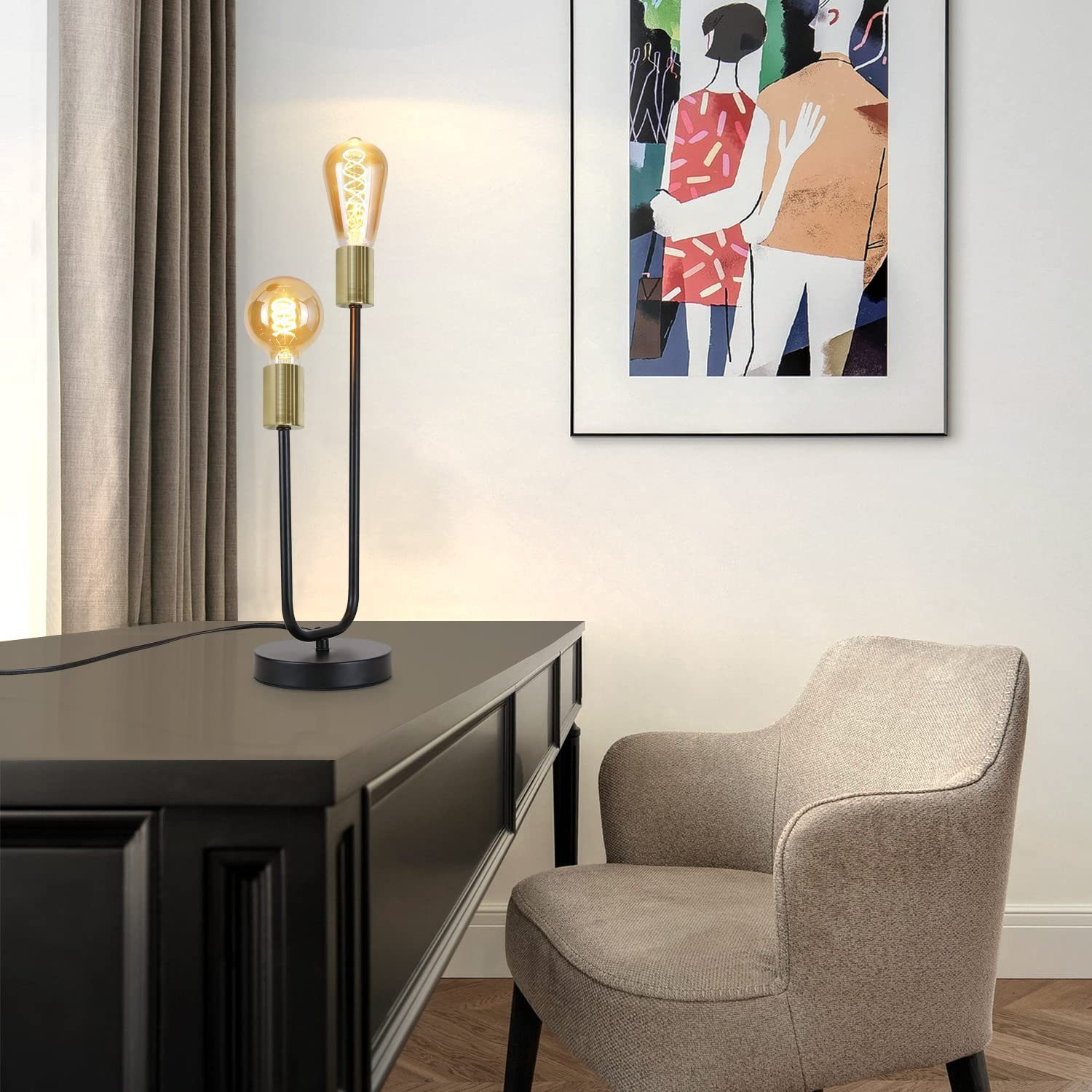 Czarny stół z lampą i dziełem sztuki. Osoba siedzi na krześle w tle.