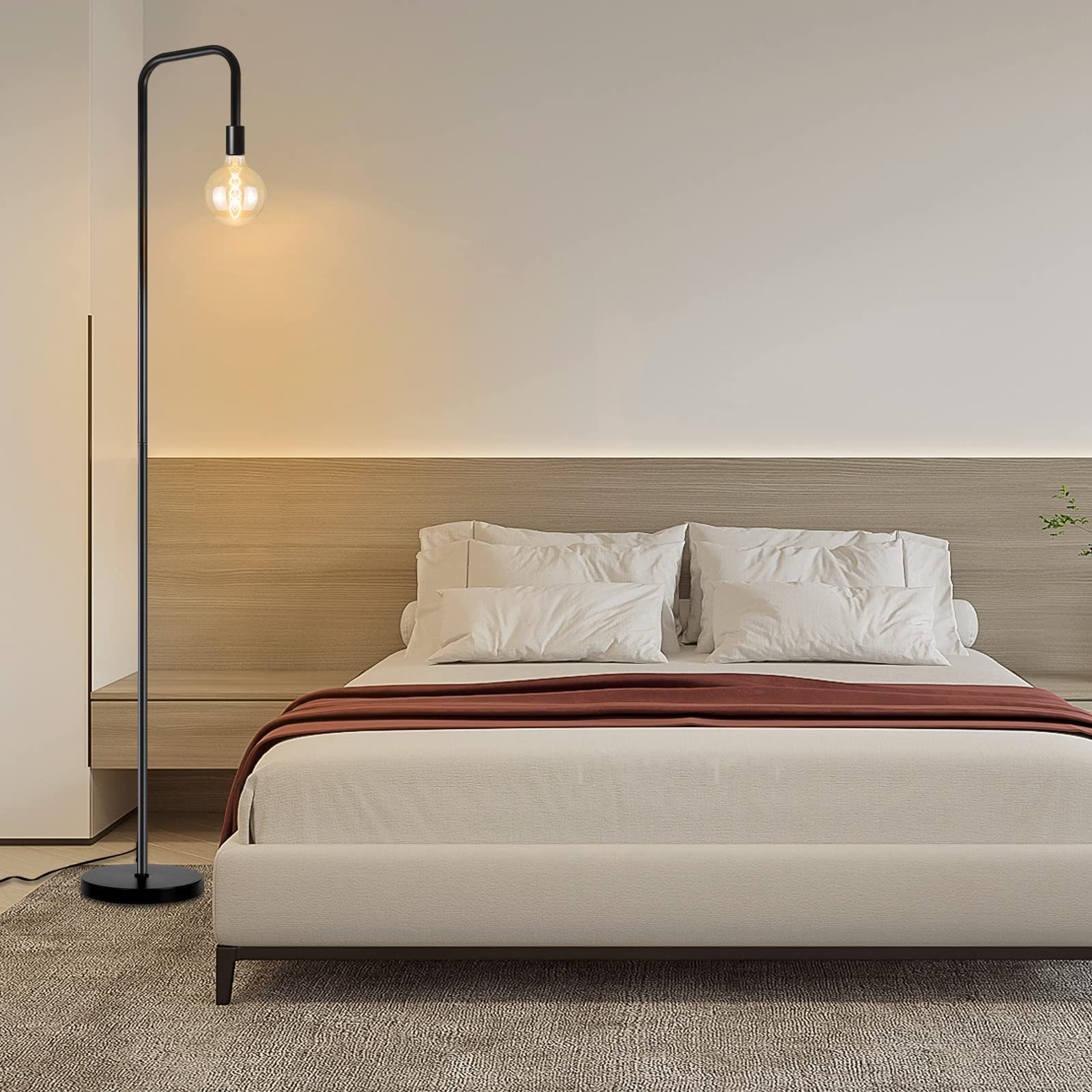 Schlafzimmerszene mit Stehlampe, Bett und neutralfarbenen Wänden.