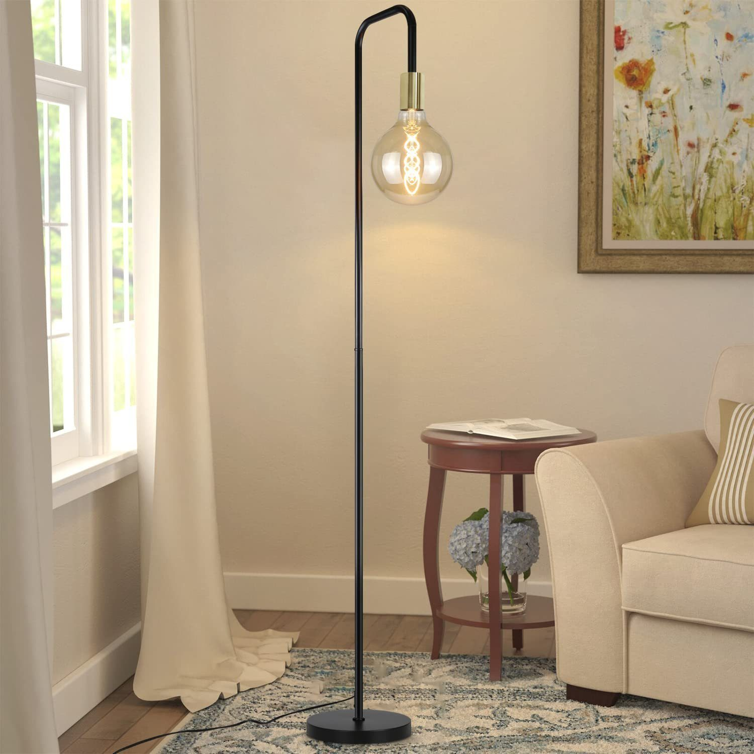 Una lampada da terra con una lampadina decorativa e un tavolo rotondo.