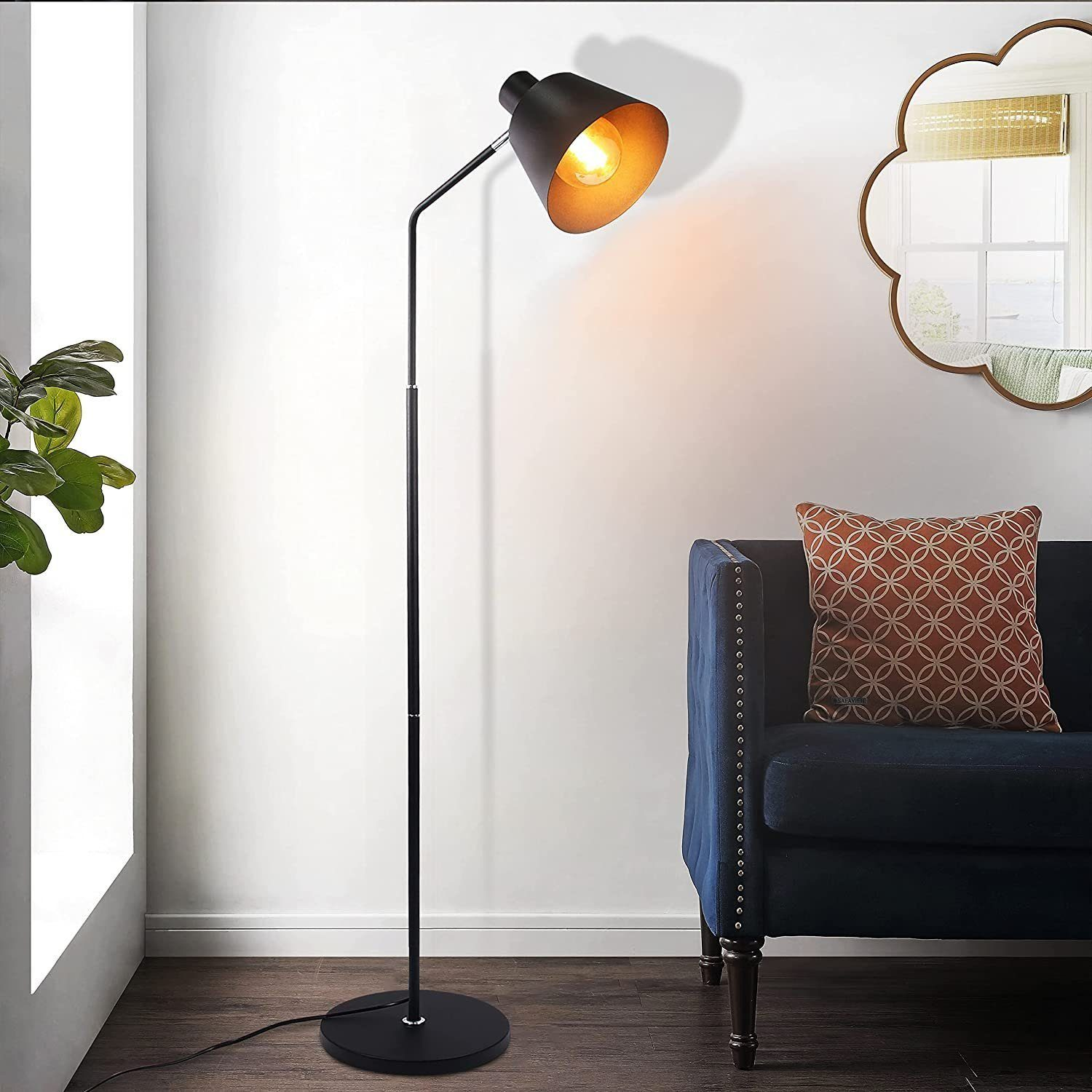 Schwarze Stehlampe mit Spot, neben einem blauen Sofa.