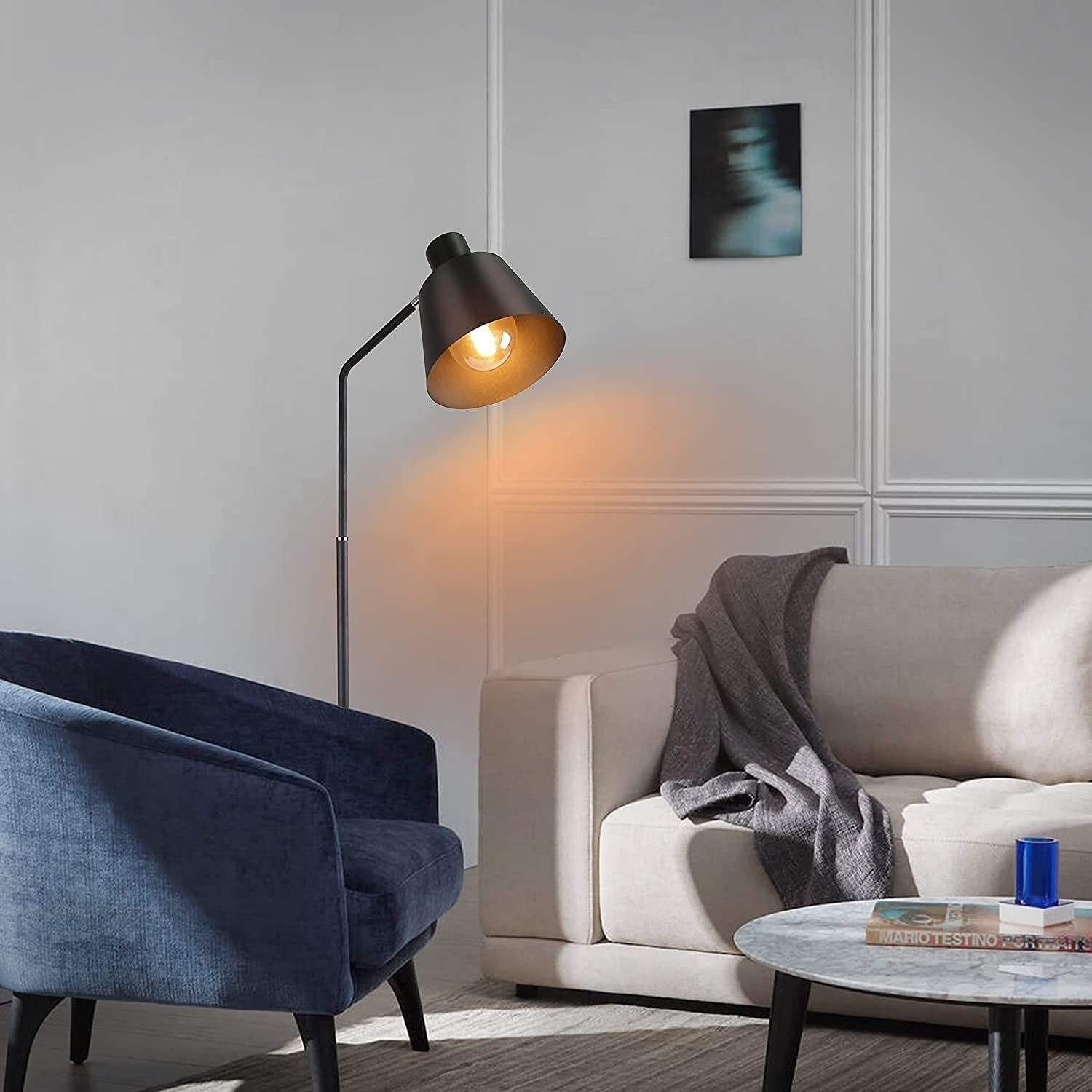 Eine schwarze Stehlampe neben einem blauen Sessel und einem beigen Sofa.