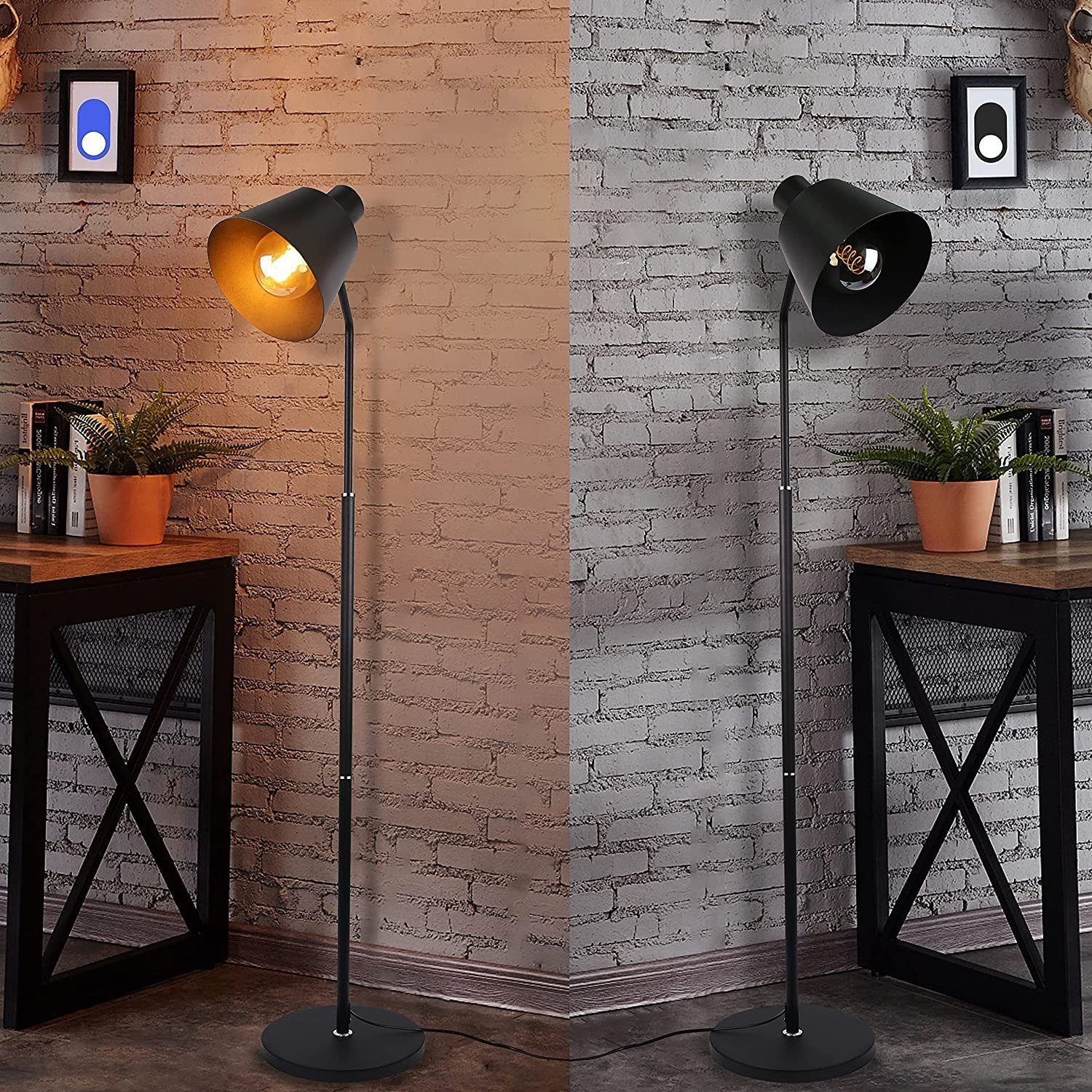 Zwei schwarze Stehlampen mit verstellbaren Schirmen, in einem Raum mit Ziegelwänden.