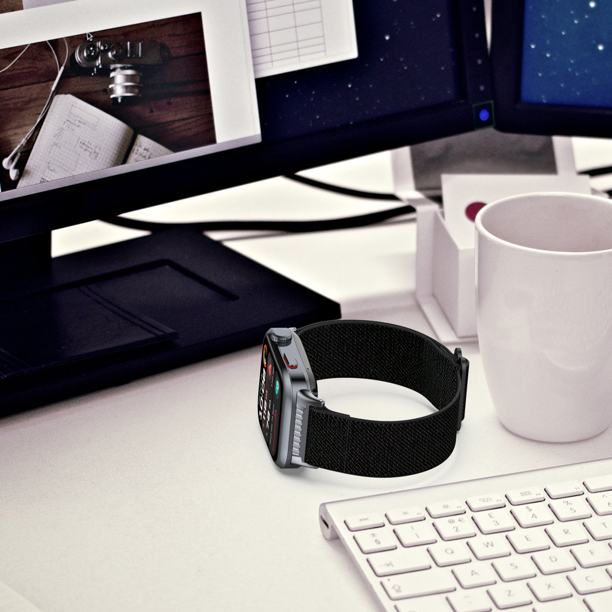 Uno smartwatch nero con cinturino nero su una scrivania bianca.