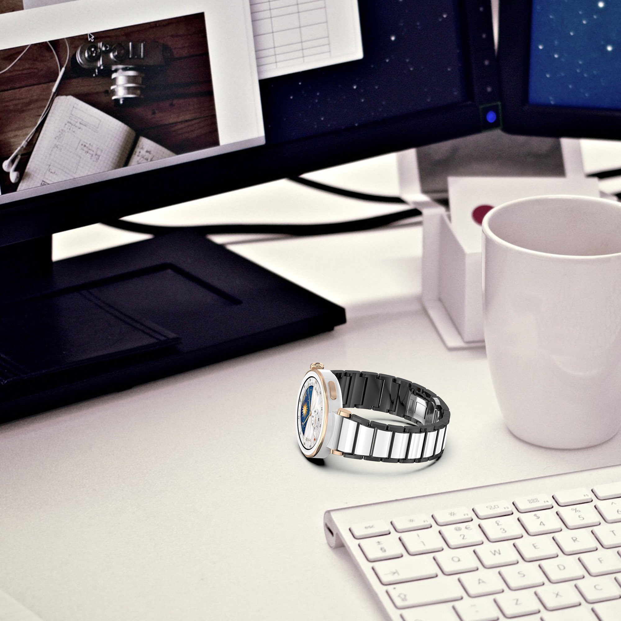 Primo piano di uno smartwatch su un tavolo bianco, con tastiera, monitor e altri oggetti.