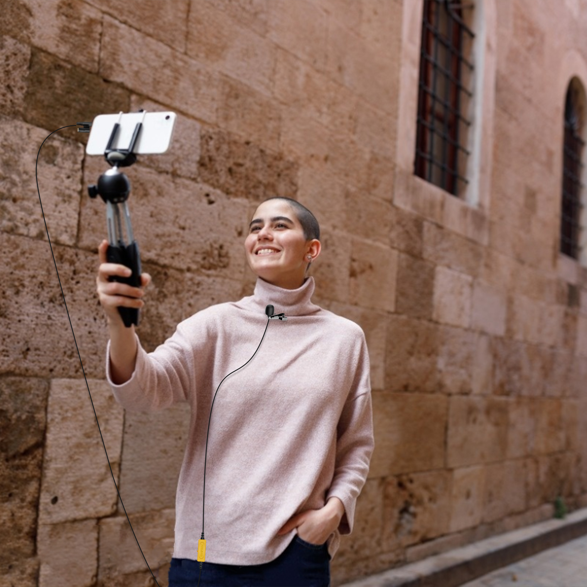 Vrouw houdt een smartphone op een statief, neemt video op met een microfoon.