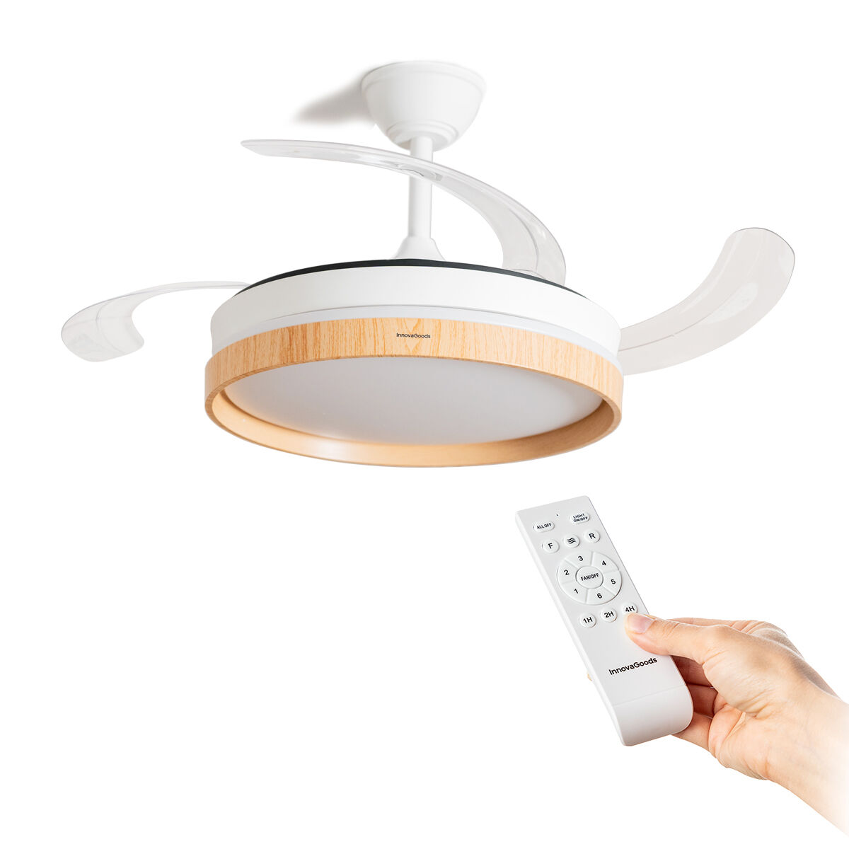 Ventilador de techo blanco con luz y moldura de madera. Una mano sostiene un mando.