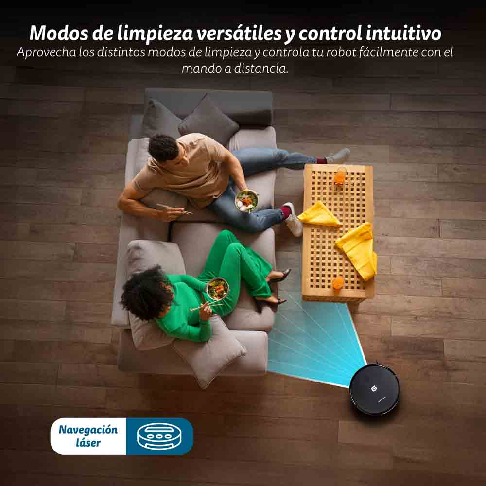 Una coppia sul divano, un robot aspirapolvere e un tavolo con oggetti.