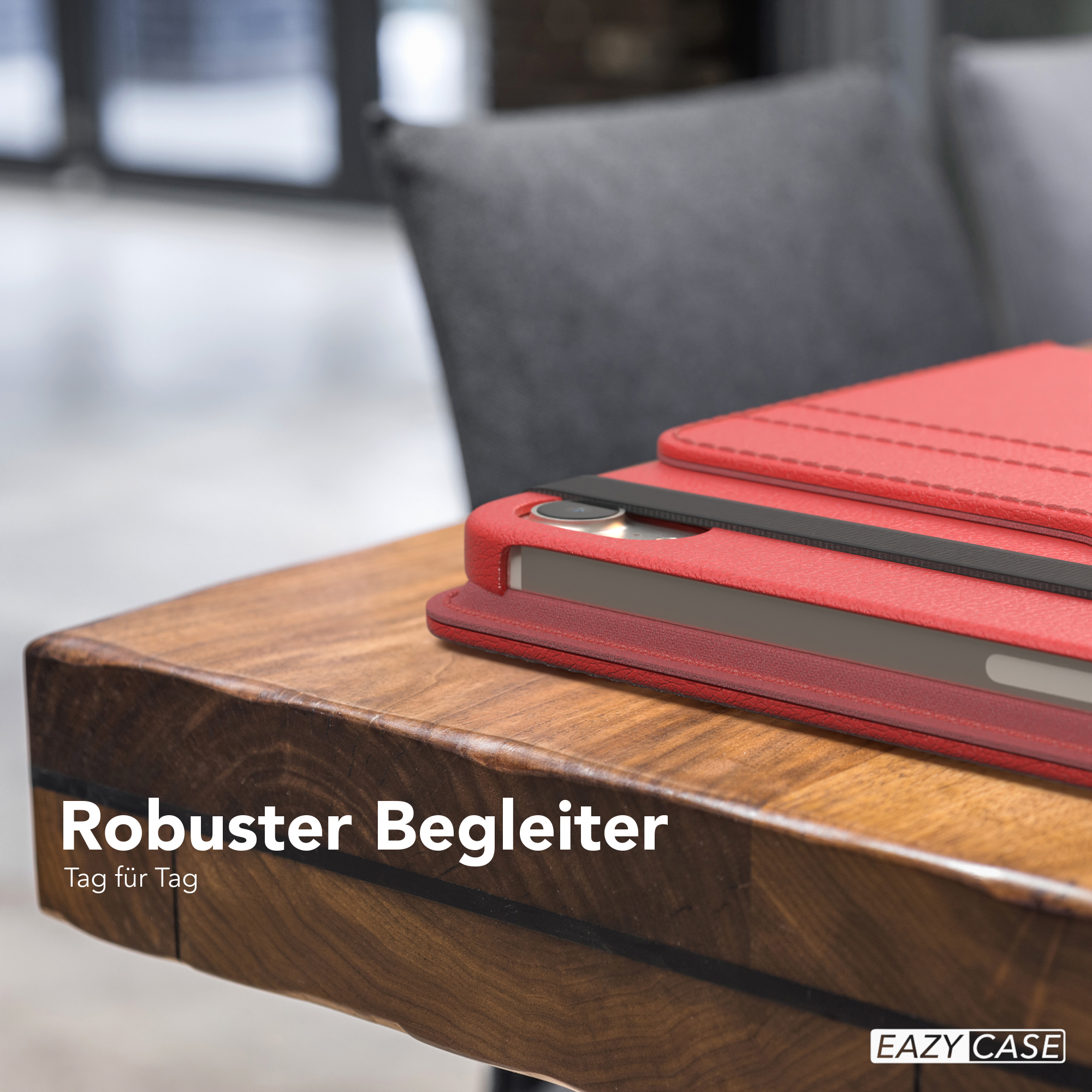 Eine rote Leder-Tablettasche auf einem Holztisch mit dem Text 'Robuster Begleiter' und 'Tag für Tag'.