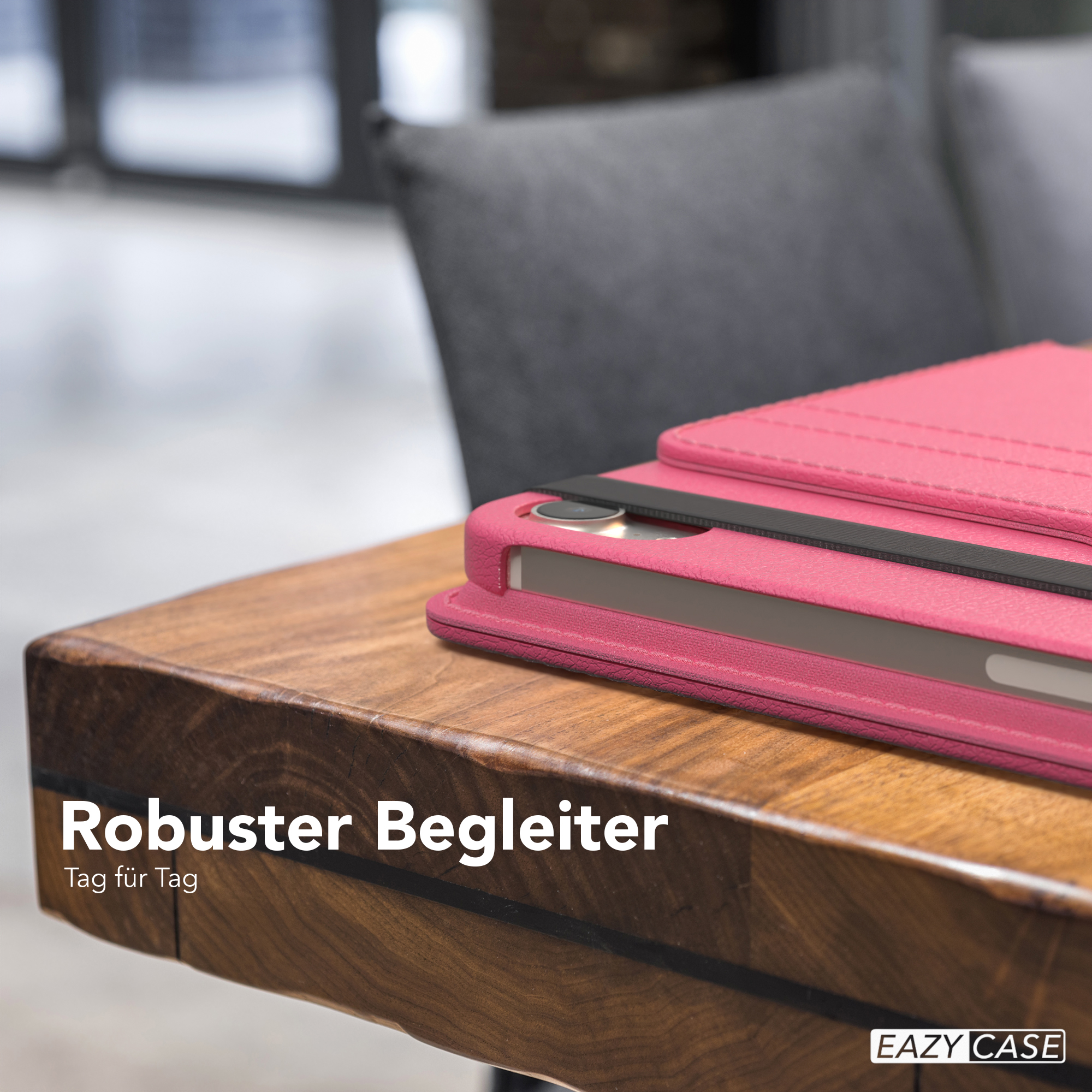 Rosa Tablet-Hülle auf einem Holztisch mit Text. Grauer Stuhl im Hintergrund.