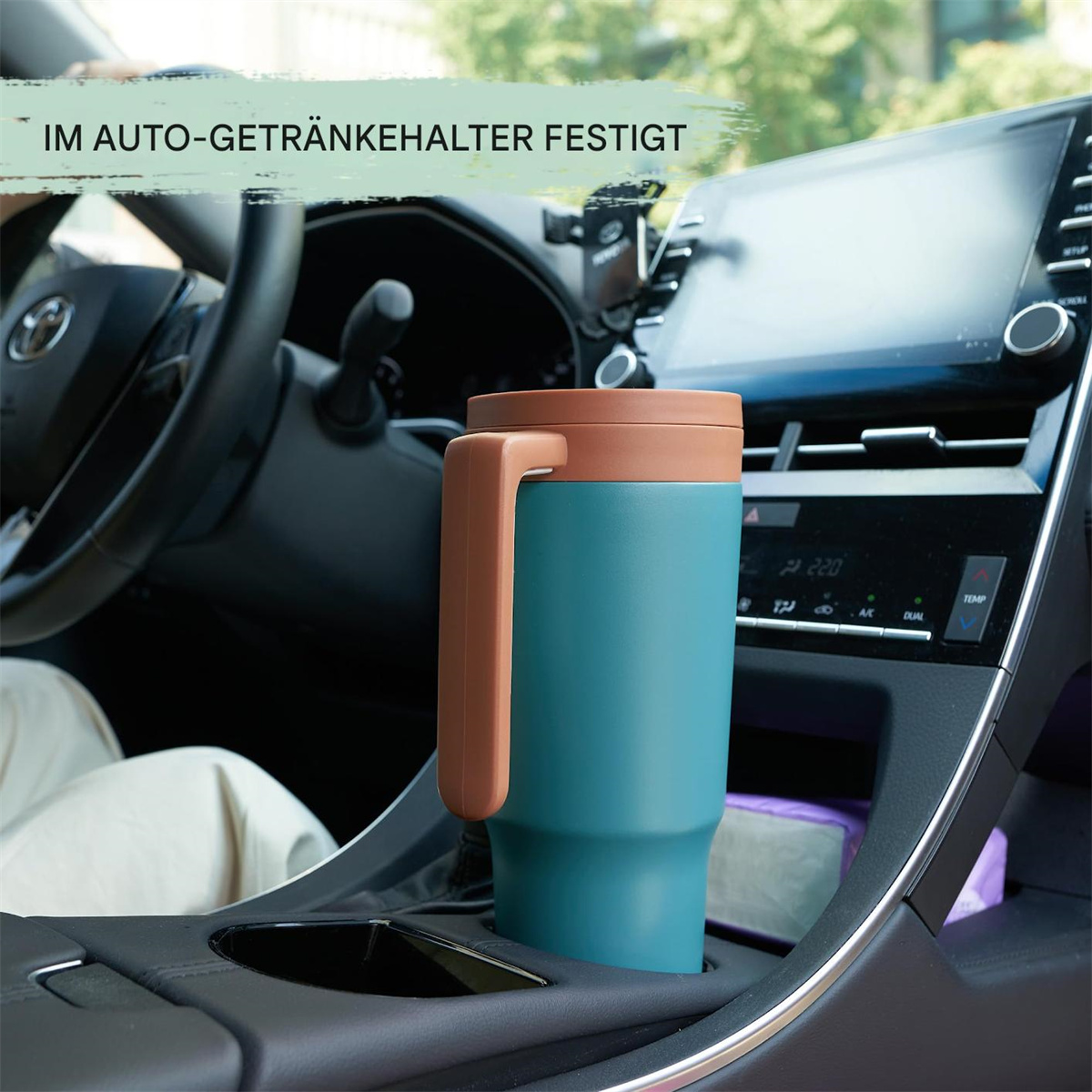 Türkis-brauner Reisebecher im Getränkehalter des Autos.