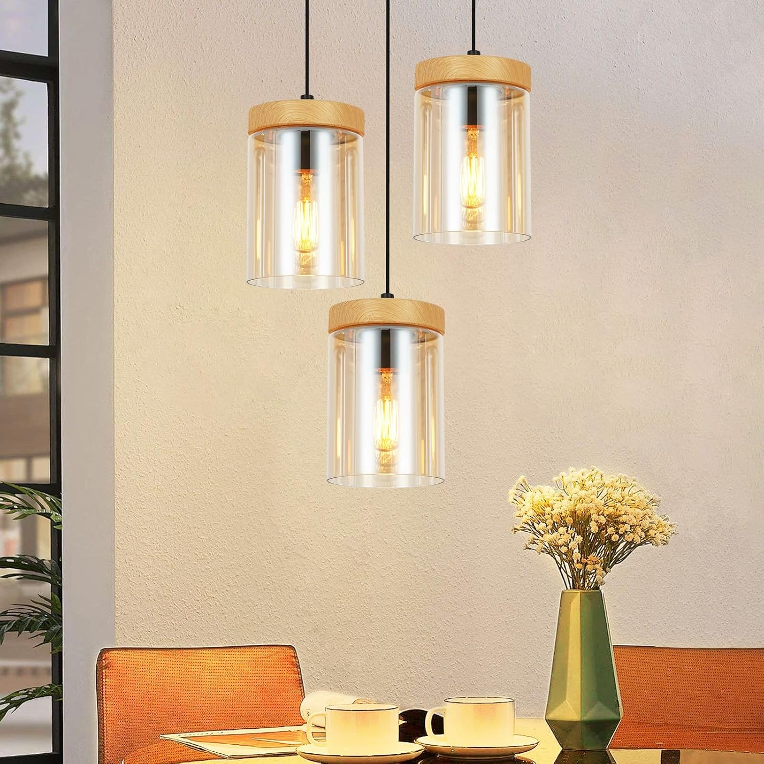 Drei hängende Pendelleuchten mit Holzaufsätzen, Glasschirmen und Edison-Glühbirnen. Der Hintergrund ist warm.