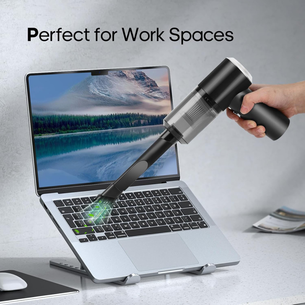Hand benutzt Mini-Staubsauger auf Laptop-Tastatur, Text: Perfect for Work Spaces.