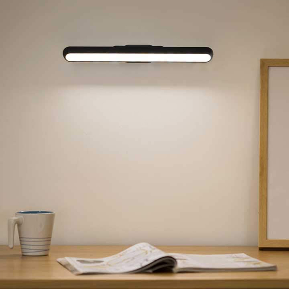 Ein Schreibtisch mit Lampe und Zeitung. Die Wand dahinter ist beige.