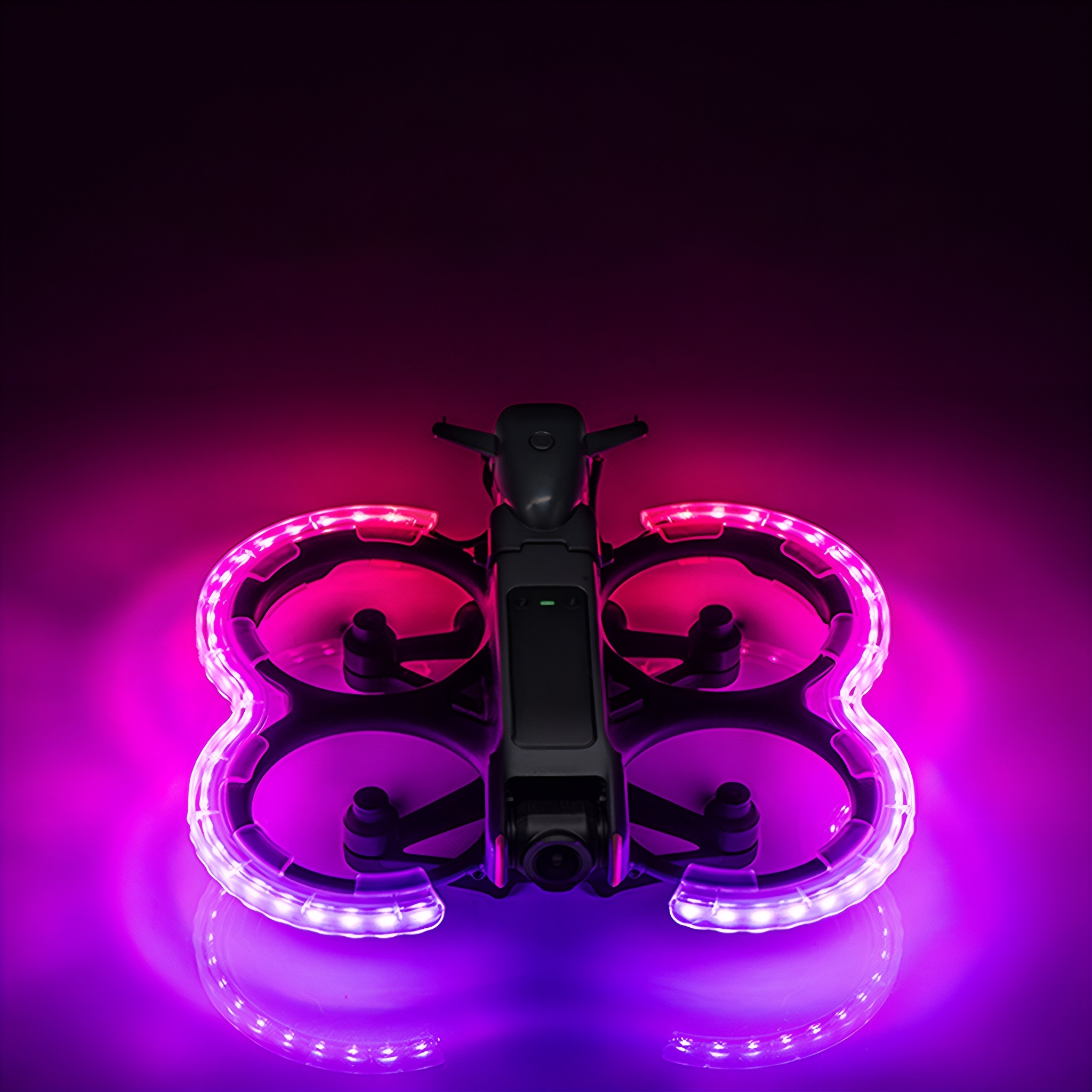 Eine schwarze Drohne mit lila Beleuchtung um die Propeller. Der Hintergrund ist ein Farbverlauf von Pink und Lila.
