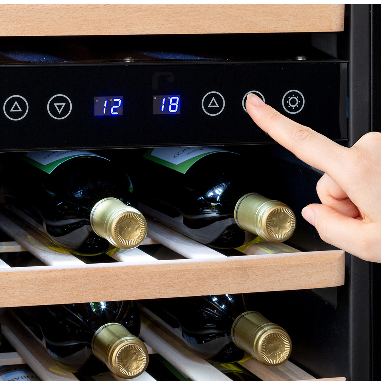 Una mano preme un pulsante sul pannello di controllo di una cantinetta, mostrando bottiglie all'interno.