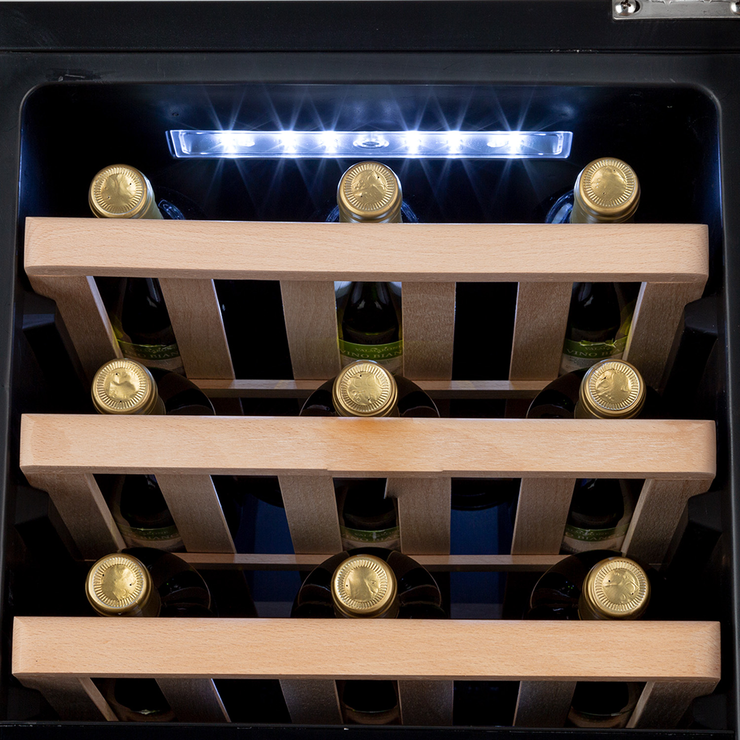 Vista interna di una cantinetta, che mostra bottiglie di vino su ripiani in legno, con illuminazione.