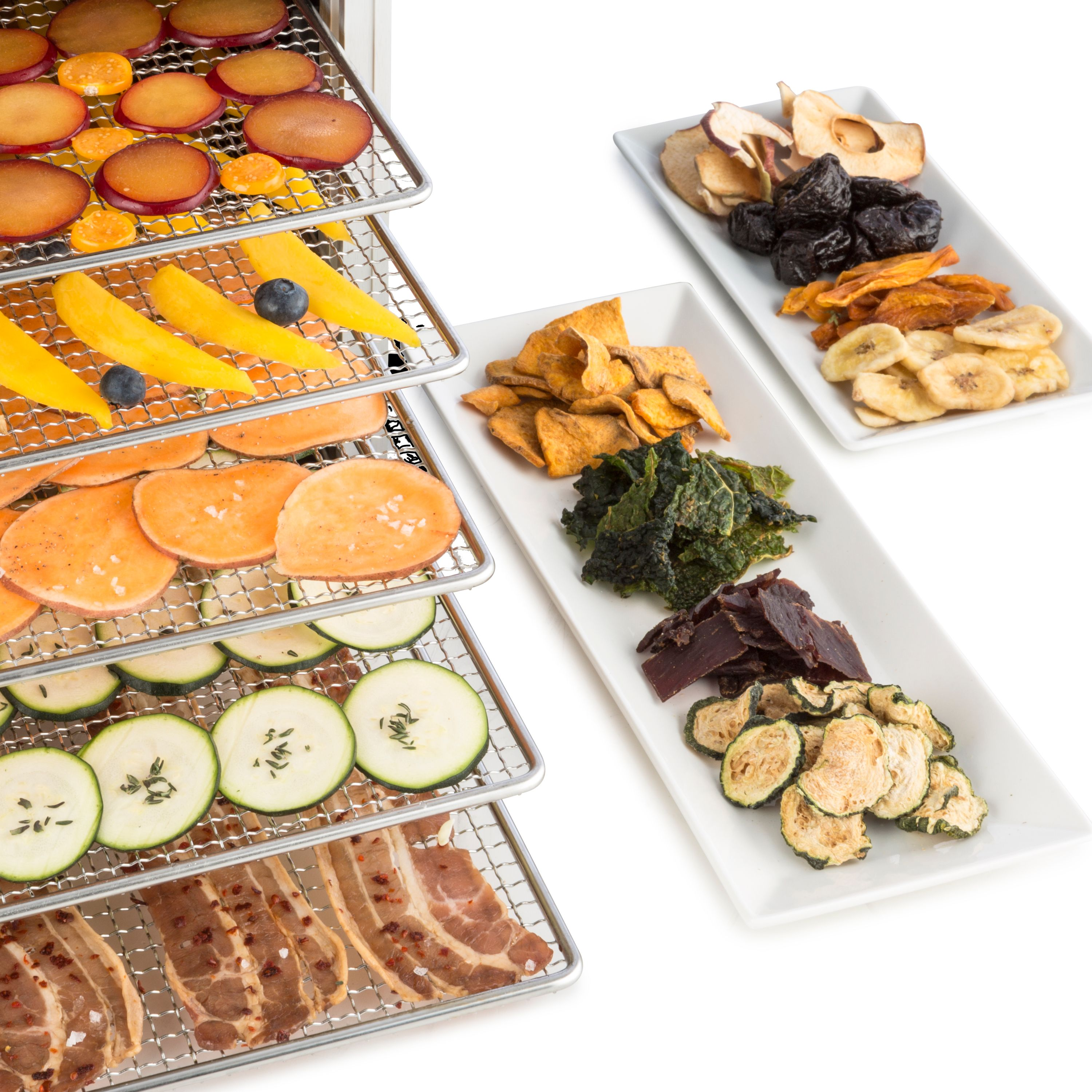 Essiccatore per alimenti con vari frutti e verdure essiccate su vassoi.