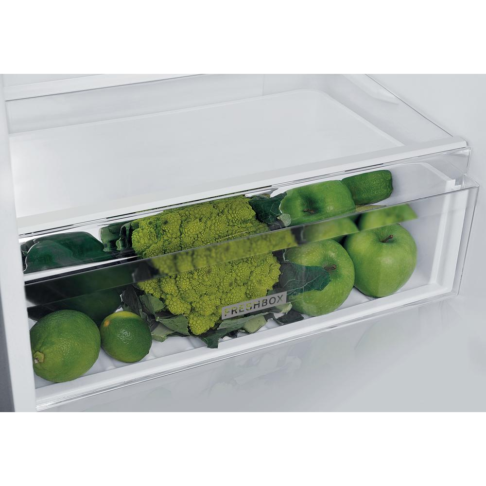 Cassetto frigo con verdure verdi: broccoli, lime, mele e cetrioli.
