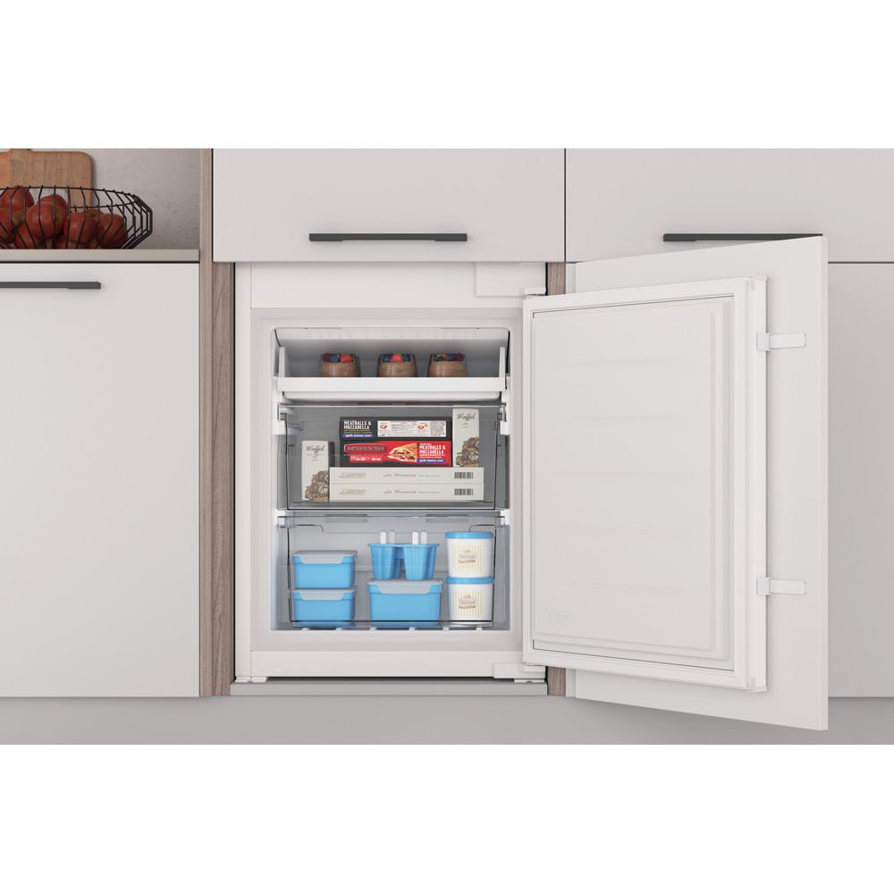 Interior de refrigerador con estantes que contienen alimentos y cajones. La puerta está abierta, mostrando el interior.