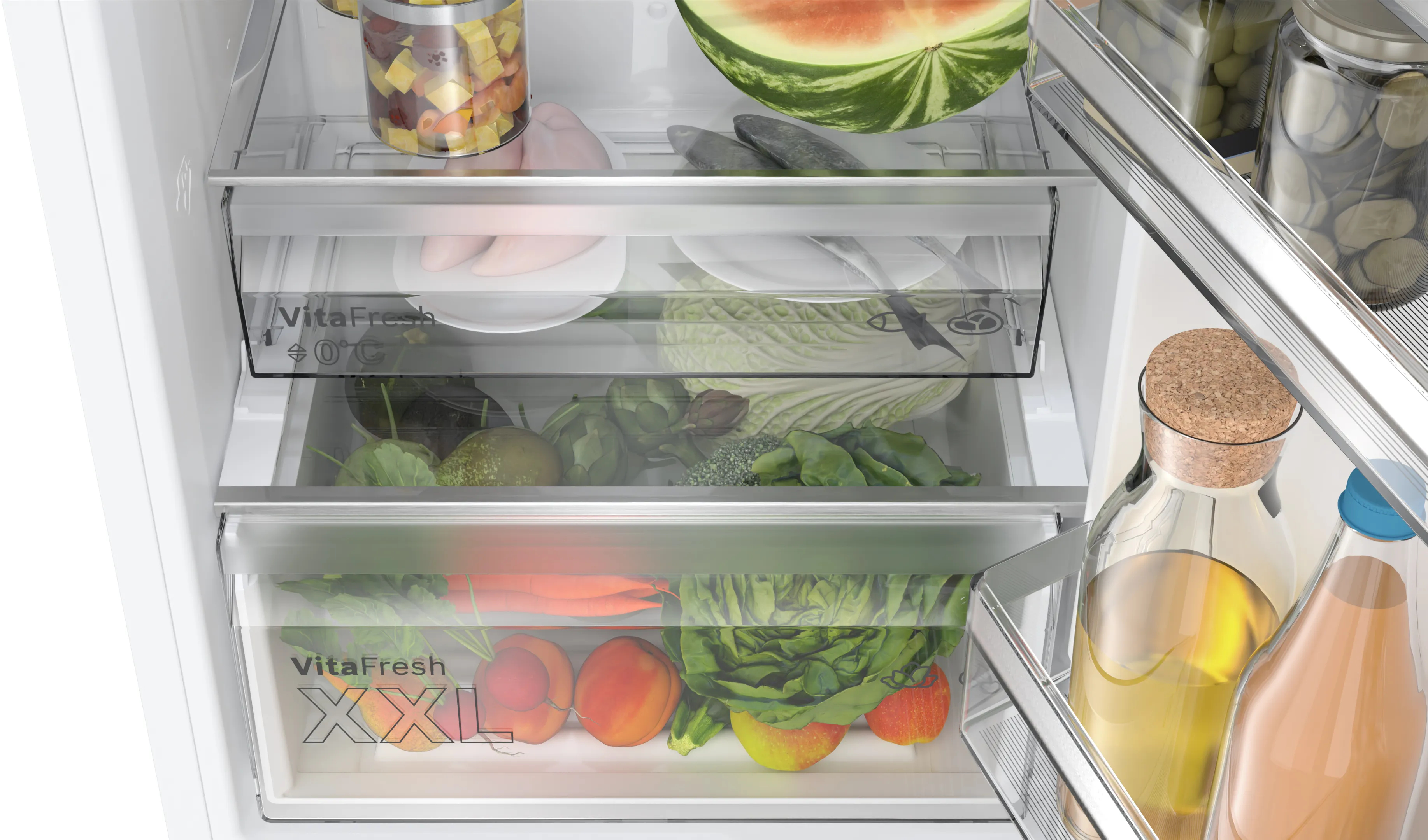 Wnętrze lodówki ze świeżymi produktami w szufladach. Widoczne słoiki i butelki.