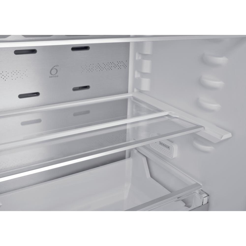 Primer plano de estantes de refrigerador vacíos, dos estantes de vidrio y una caja abierta.