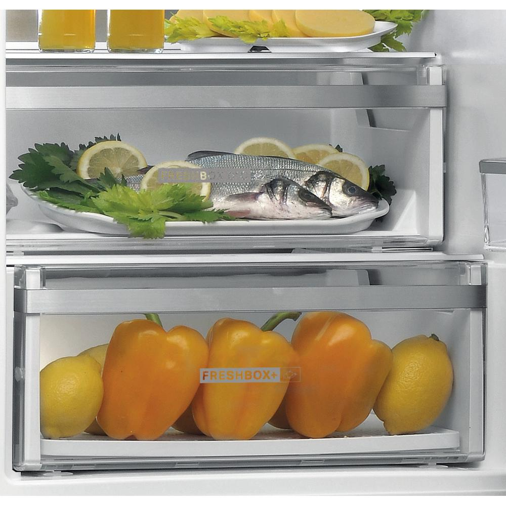 Interior del refrigerador con comida. Pescado, limones y pimientos en cajones Freshbox+.
