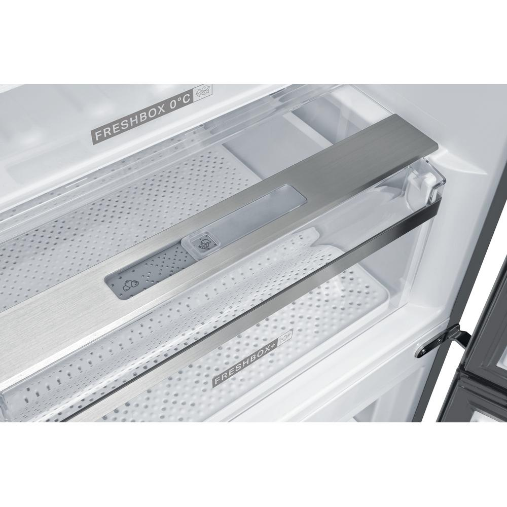 Dentro de un refrigerador, mostrando el área Freshbox con panel de metal y almacenamiento transparente.