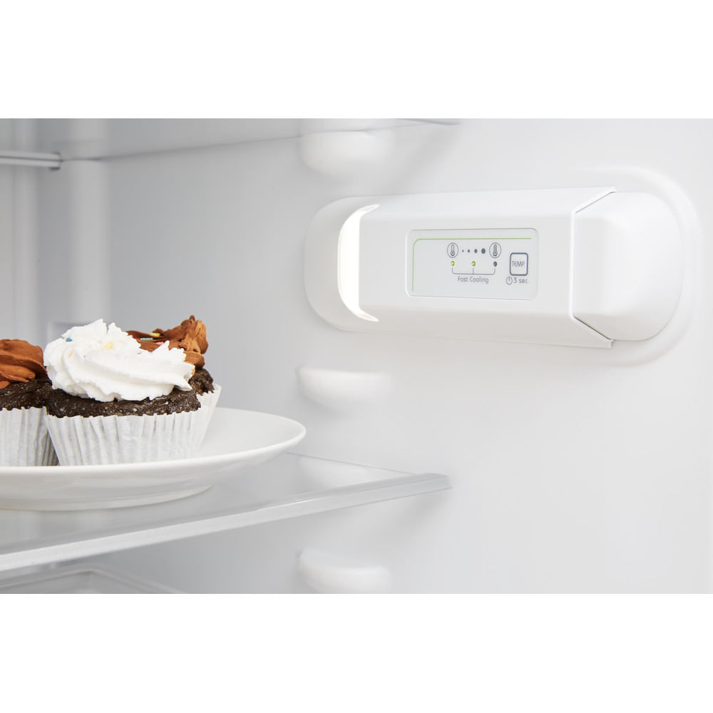 Dentro de un refrigerador: cupcakes en un plato, panel de control y estantes.