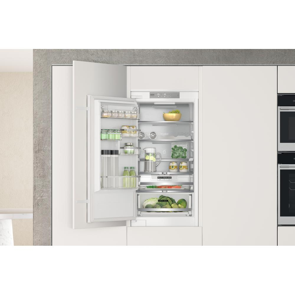 White refrigerator with open door revealing organized shelves of food items. Clean and modern.
