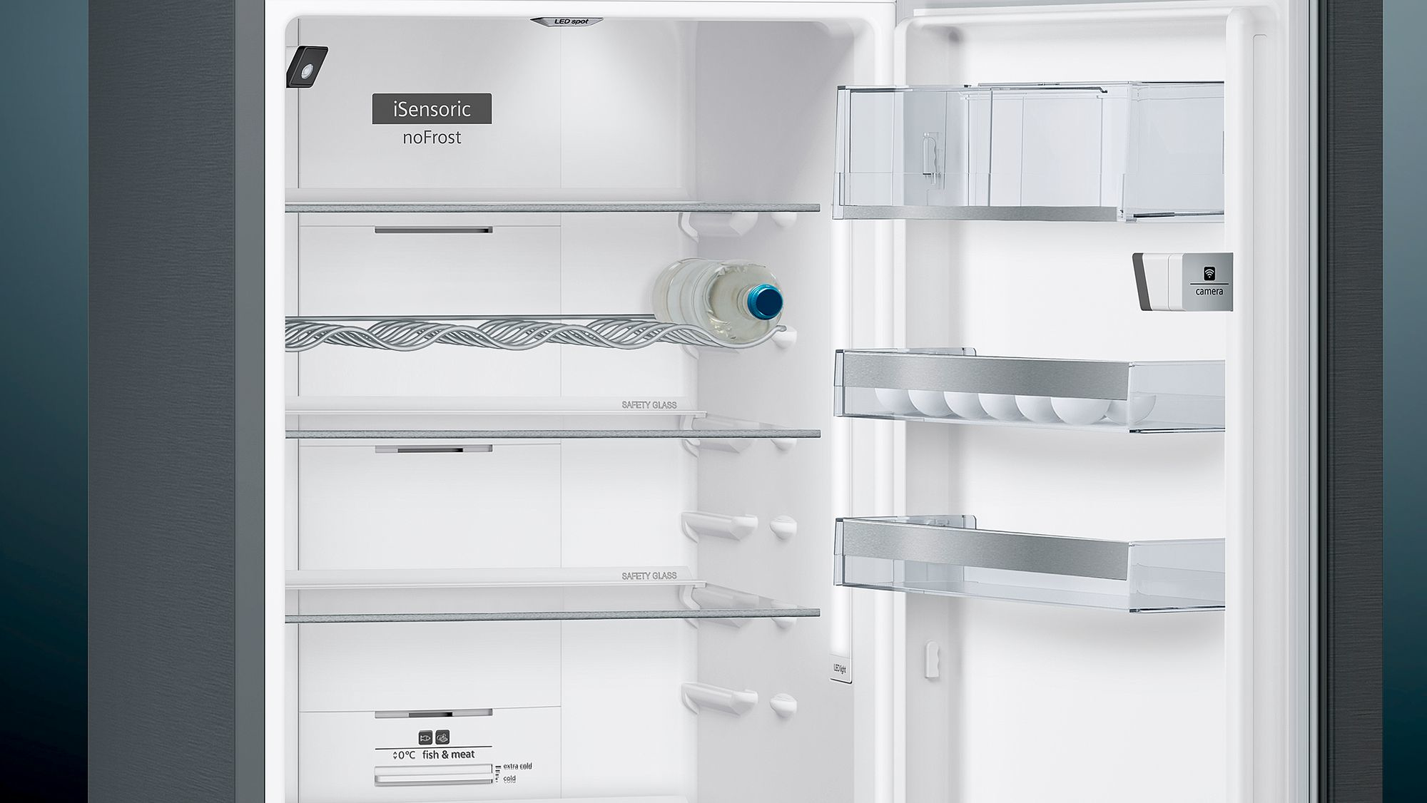 Dentro de un refrigerador, en su mayoría vacío con estantes. Hay una botella de agua. El interior es blanco.