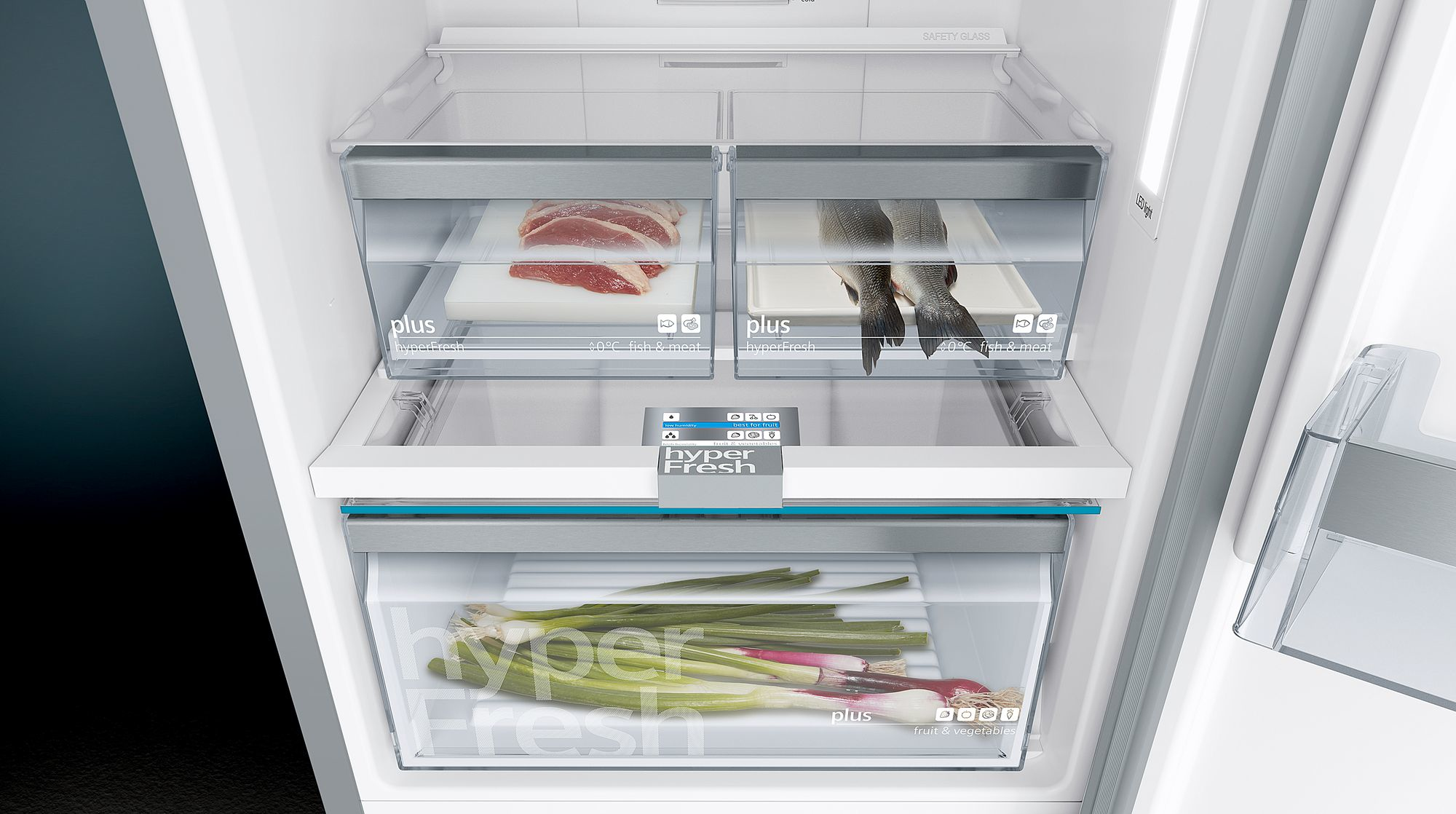 Interior de refrigerador con cajones abiertos. Contiene carne, pescado y verduras en compartimentos etiquetados.