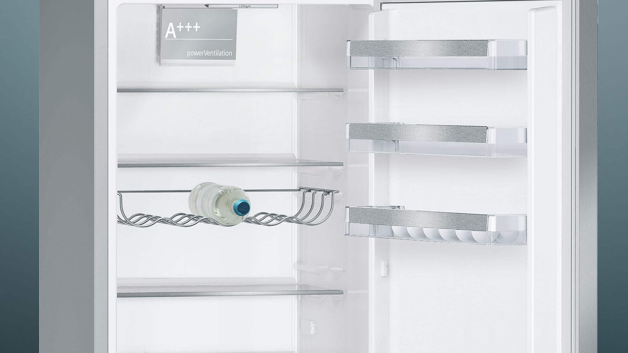 Otwarta lodówka z półkami i butelką wody w środku, białe wnętrze.
