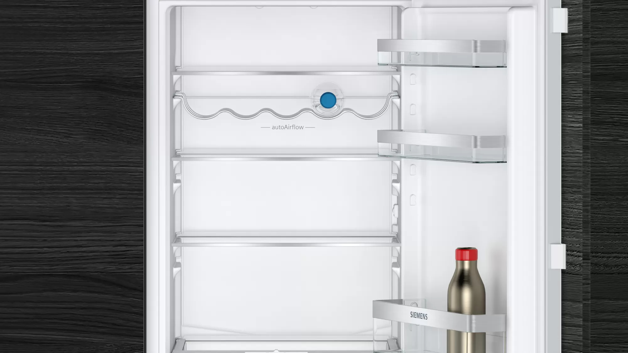 L'interno di un frigorifero con ripiani e una bottiglia d'acqua.