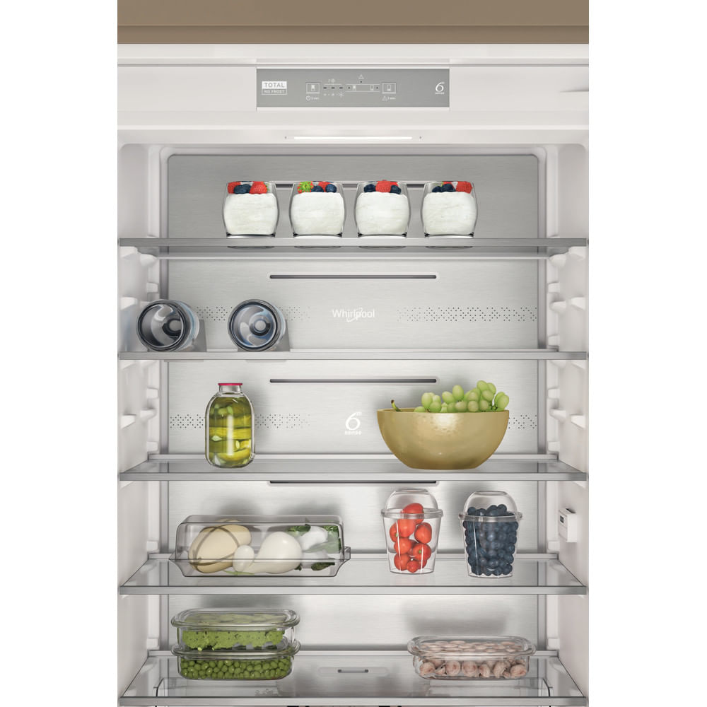 Zbliżenie wnętrza lodówki z półkami trzymającymi pojemniki z żywnością.