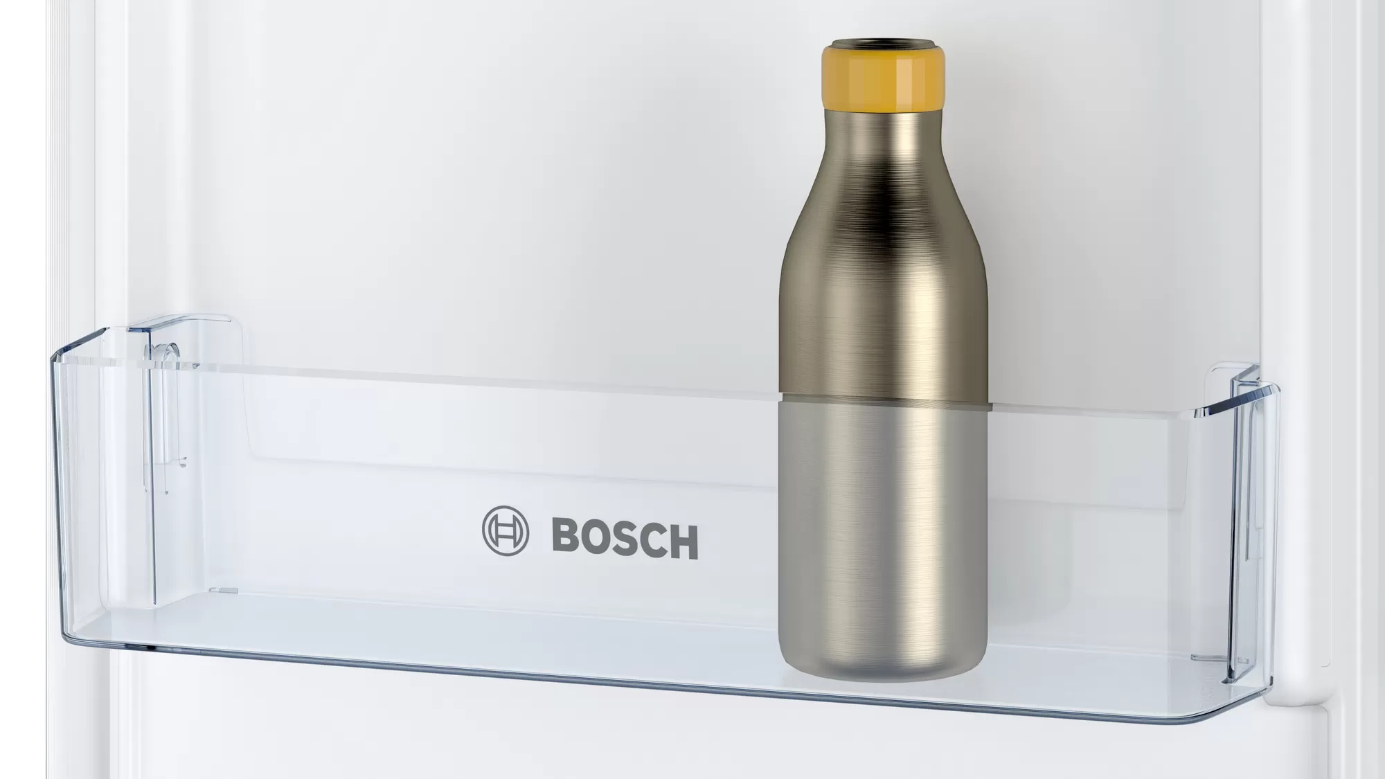 Una bottiglia in acciaio inossidabile con tappo giallo in un ripiano del frigorifero. Il logo Bosch è visibile.