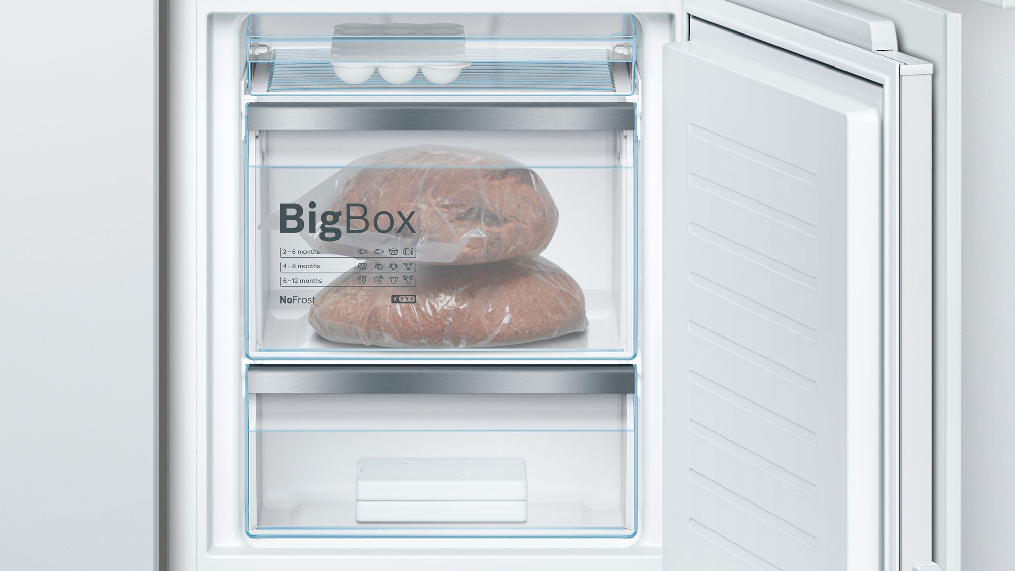 In einem weißen Kühlschrank ist eine BigBox mit Brot gefüllt. Darüber liegen Eier in einem Regal.