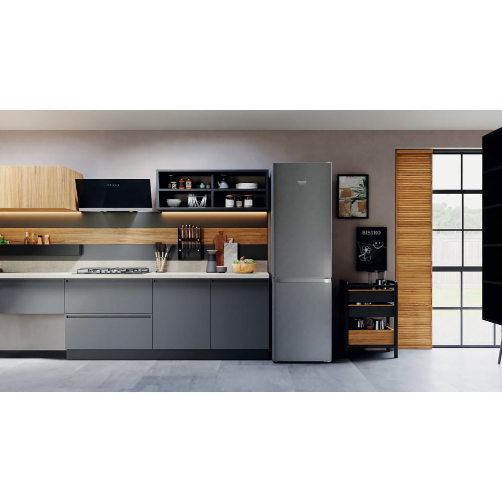 Una cocina con refrigerador, gabinetes y una encimera. Un letrero de bistró está en un carrito.