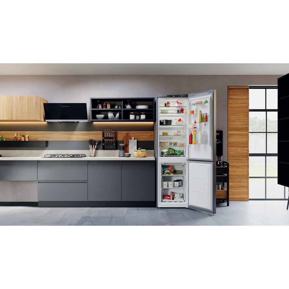 Una cocina con nevera abierta. La nevera está llena de comida y bebidas.