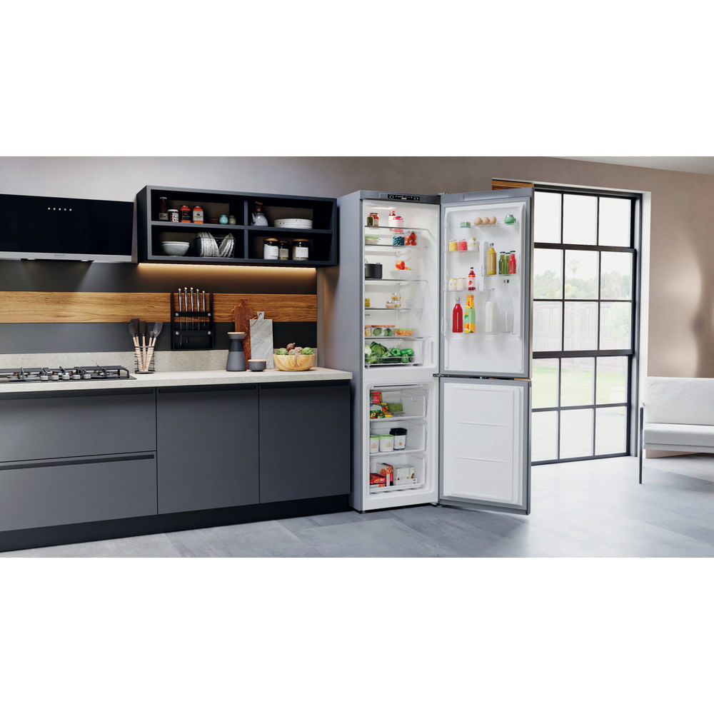 Escena de cocina, refrigerador con puerta abierta. Encimera de cocina, gabinetes y decoración.